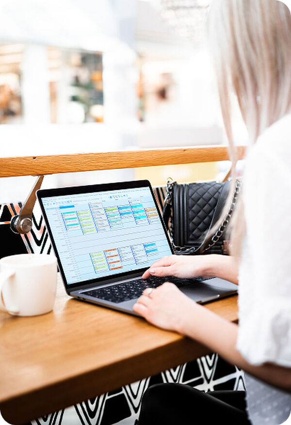 Vrouw werkt op een laptop met de planning van Admin2Win